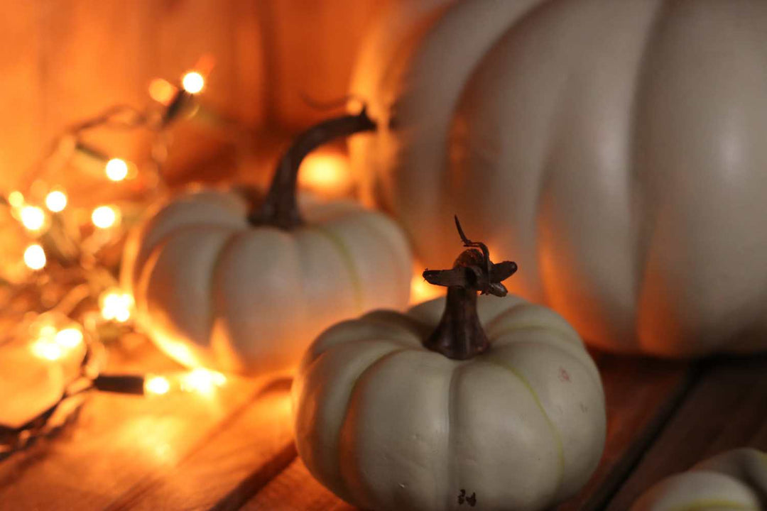 white pumpkins and orange mini lights